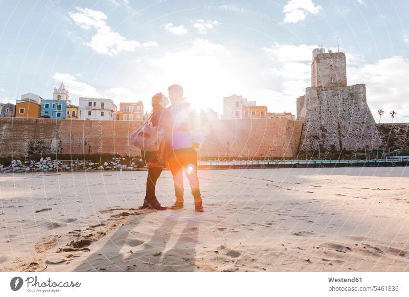 Italy, Molise, Termoli, young couple in the beach at sunrise beaches twosomes partnership couples togetherness in love romantic lyrical Romance close closeness