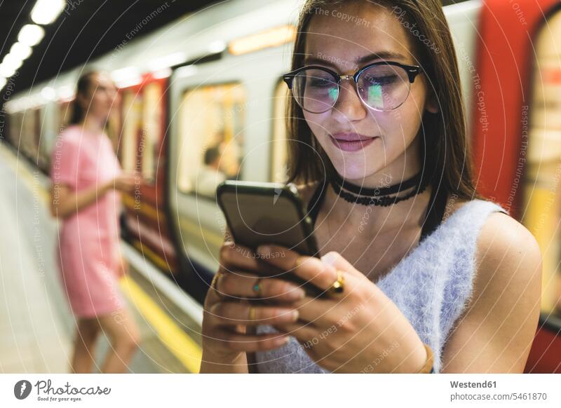 Teenage girl using cell phone at subway station underground train mobile phone mobiles mobile phones Cellphone cell phones woman females women Teenage Girls
