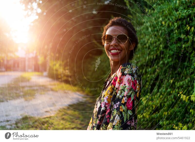 Portrait of happy young woman wearing sunglasses outdoors at sunset sun glasses Pair Of Sunglasses sunsets sundown portrait portraits females women happiness