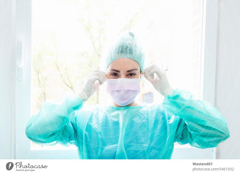 Close-up of nurse wearing surgical mask against window in hospital color image colour image indoors indoor shot indoor shots interior interior view Interiors