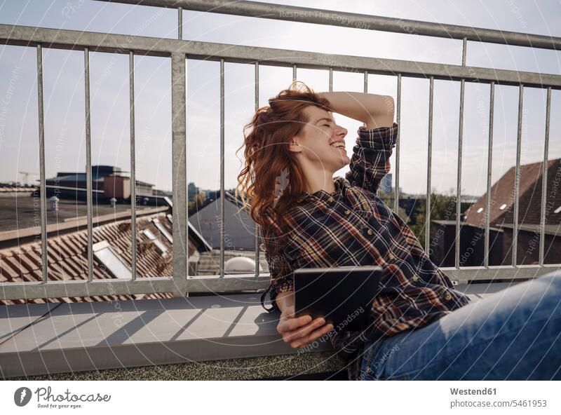 Happy redheaded woman with tablet relaxing on rooftop terrace business life business world business person businesspeople business woman business women