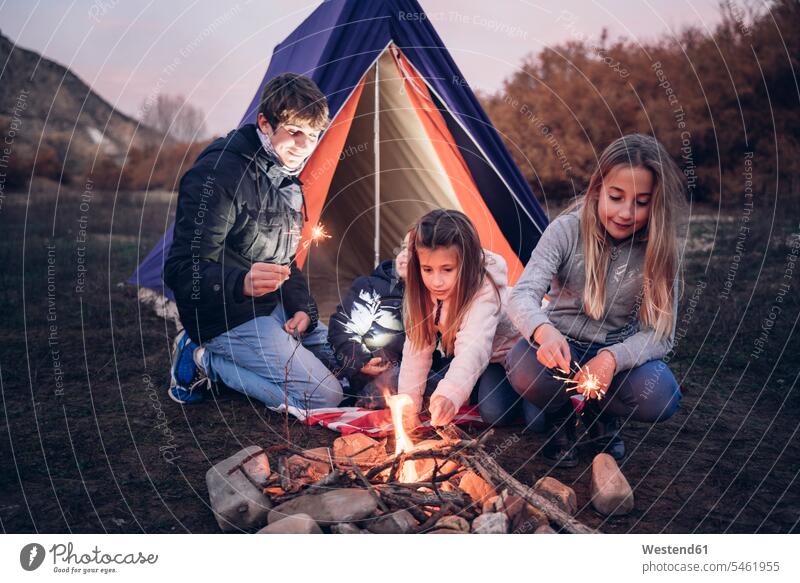 Group of four children camping in the evening Late Evening delight enjoyment Pleasant pleasure Bonfire Campfire Blaze experience Experiences free Liberty