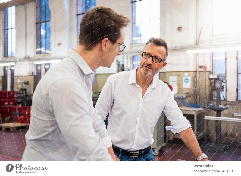 Two businessmen discussing in factory factories discussion colleagues Businessman Business man Businessmen Business men business people businesspeople