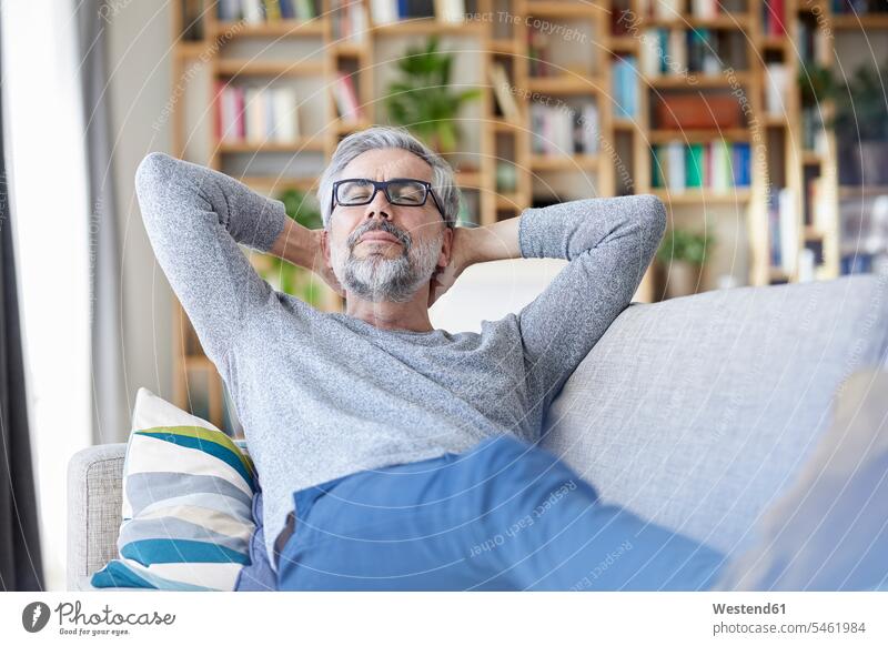 Portrait of mature relaxing on couch at home man men males portrait portraits relaxation settee sofa sofas couches settees Adults grown-ups grownups adult