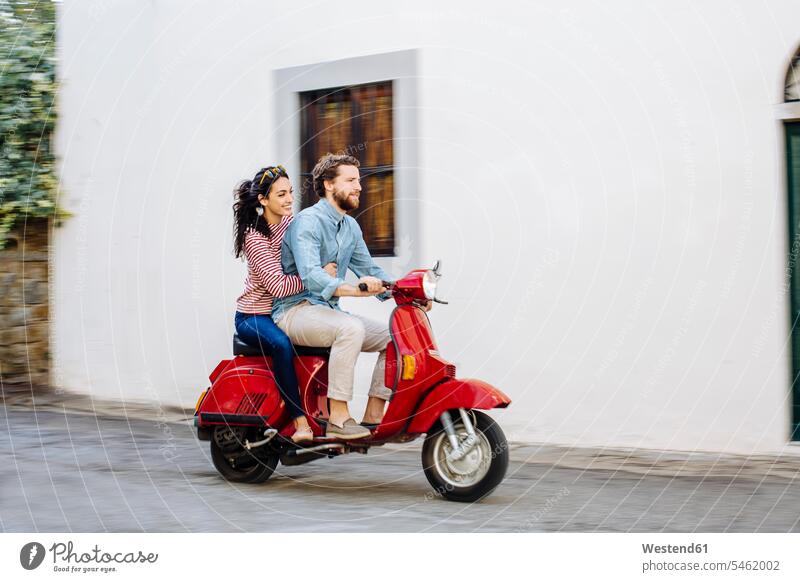 Couple enjoying road trip on Vespa color image colour image Tuscany Italy tourism touristic leisure activity leisure activities free time leisure time