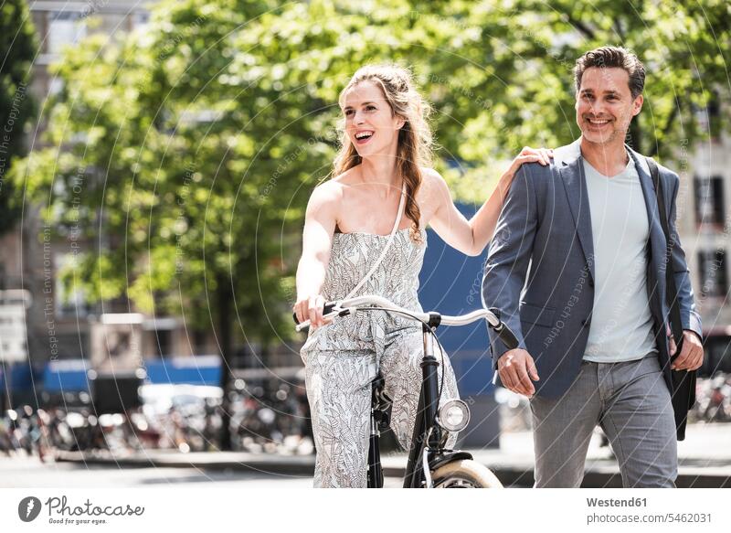 Happy couple with bicycle in the city town cities towns bikes bicycles twosomes partnership couples happiness happy outdoors outdoor shots location shot
