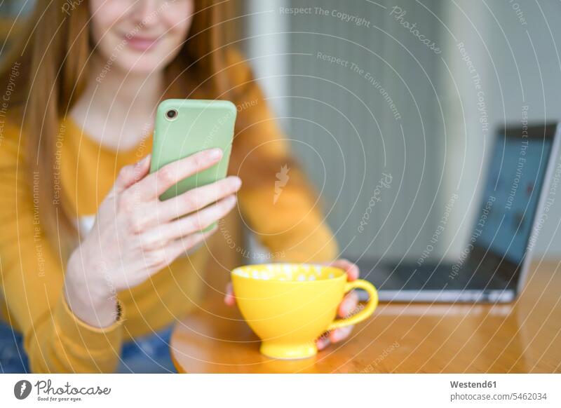 Close-up of woman with cup of coffee and cell phone at home human human being human beings humans person persons caucasian appearance caucasian ethnicity