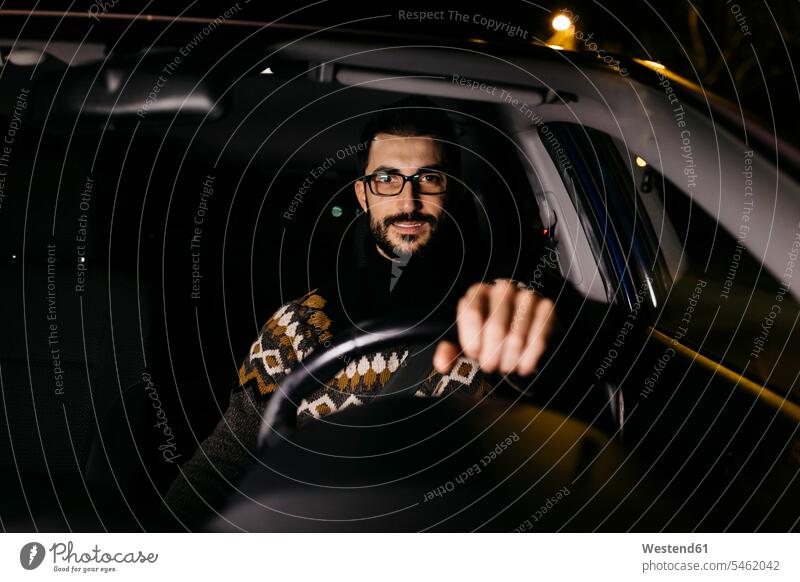 Portrait of confident man driving car at night car driving motoring portrait portraits confidence men males by night nite night photography drive automobile