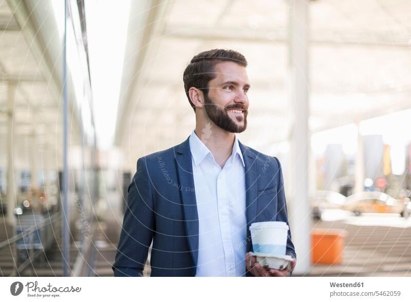Smiling young businessman holding tray with takeaway coffee Coffee Tray Trays smiling smile Businessman Business man Businessmen Business men Drink beverages