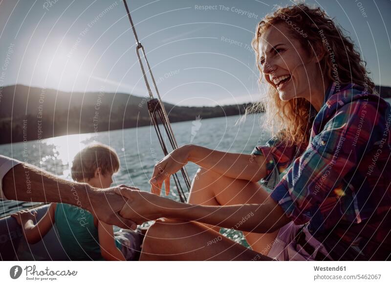 Happy family on a sailing boat sailboat Sail Boat Sailboats sailing boats families happiness happy vessel water vehicle people persons human being humans