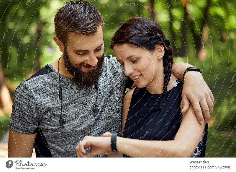 Happy sporty couple checking smartwatch human human being human beings humans person persons caucasian appearance caucasian ethnicity european 2 2 people