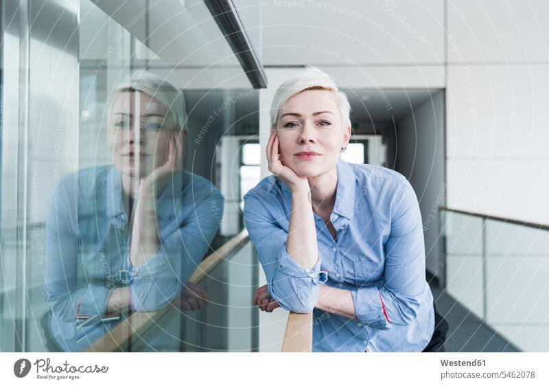 Portrait of woman on office floor leaning on railing Railing Railings office suite females women rested on portrait portraits Adults grown-ups grownups adult