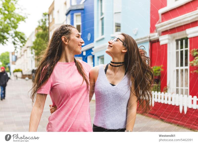 Two happy teenage girls on the go in the city happiness Teenage Girls female teenagers woman females women town cities towns on the move on the way on the road