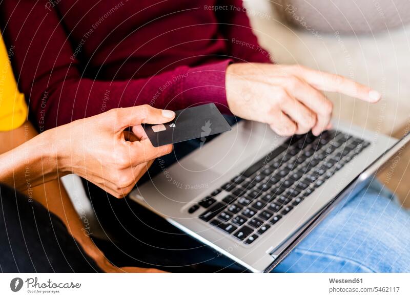 Close-up of couple at home shopping online with laptop and credit card finance financial credit cards debit card direct payment jumper sweater Sweaters chip