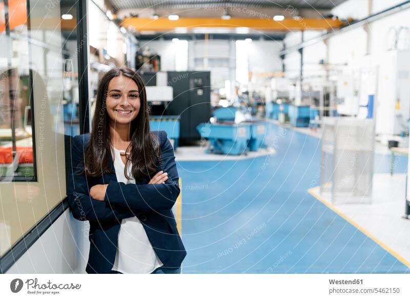 Confident woman working in high tech enterprise, standing in factory workshop with arms crossed employee employess Arms Folded Folded Arms Crossed Arms