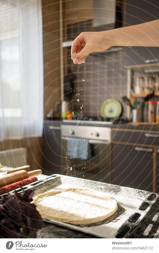 Boy's hand scattering flour on pizza base bake at home free time leisure time Lifestyle Alimentation food Food and Drinks Nutrition foods Pizza Pizzas Sausages