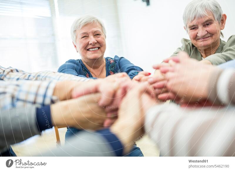 Group of active seniors stacking hands, symbolizing solidarity human human being human beings humans person persons caucasian appearance caucasian ethnicity