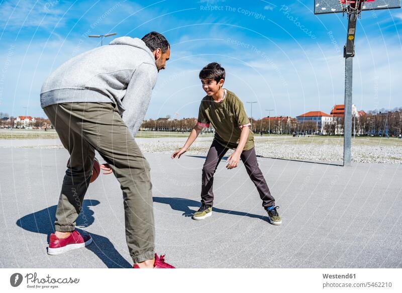 Father and son playing basketball on court outdoors sons manchild manchildren father pa fathers daddy dads papa basketballs basketball ground basketball court
