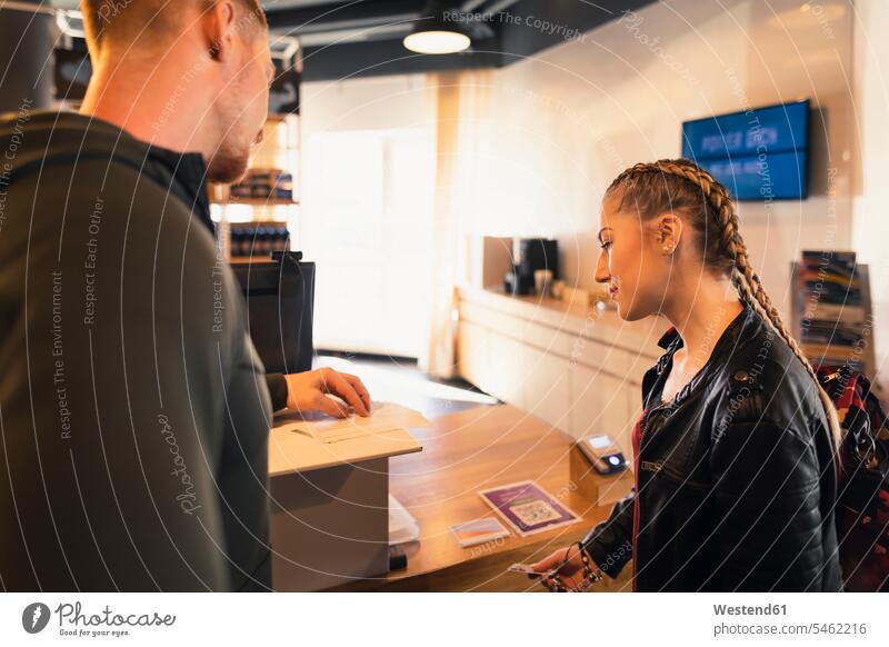 Young woman looking at application form at front desk of a gym human human being human beings humans person persons caucasian appearance caucasian ethnicity