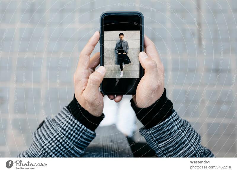 Man holding smartphone with photo of himself, close-up photograph photographs photos Smartphone iPhone Smartphones man men males image images picture pictures