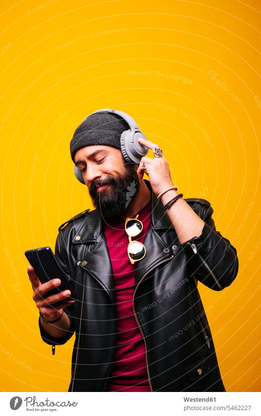 Portrait of a stylish young man in studio with smartphone and headphones human human being human beings humans person persons African black black ethnicity