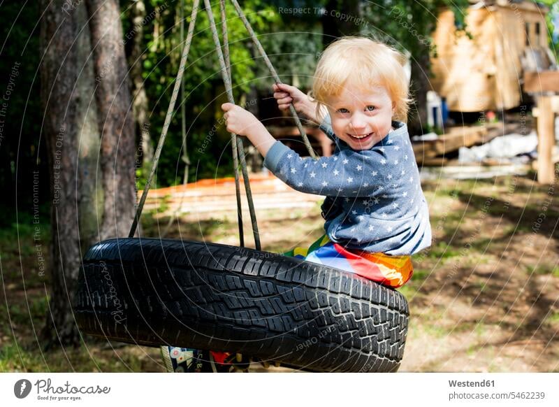 Portrait of happy toddler girl sitting on tire swing ropes playground swing Swing - Play Equipment swing set swings swingset Tire - Vehicle Part tires tyre