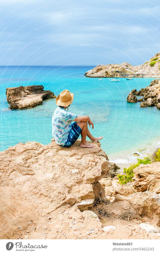 Man sitting on cliff looking at sea, Ibiza, Spain human human being human beings humans person persons caucasian appearance caucasian ethnicity european 1