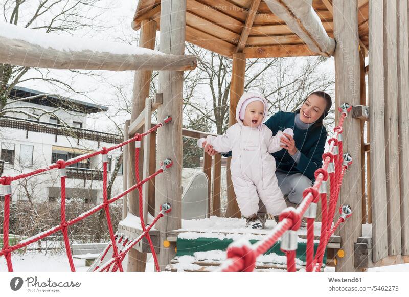 Mother and little daughter on climbing frame in winter daughters Climbing Frame mother mommy mothers ma mummy mama hibernal child children family families