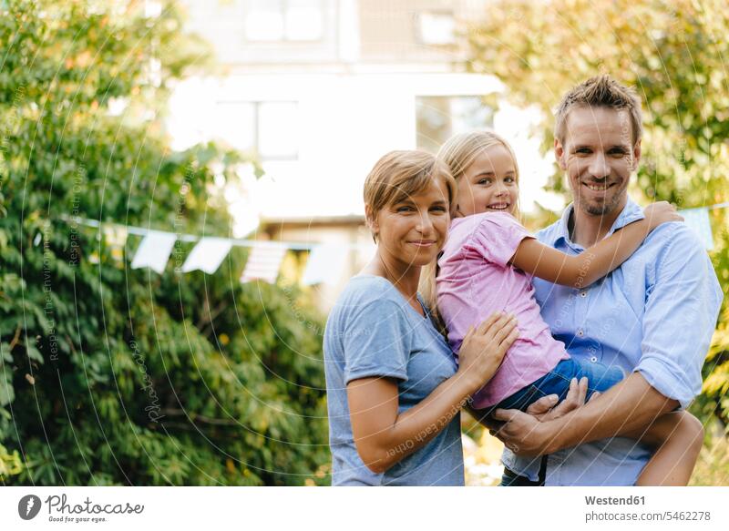 Portrait of happy family in garden gardens domestic garden happiness portrait portraits families people persons human being humans human beings bonding