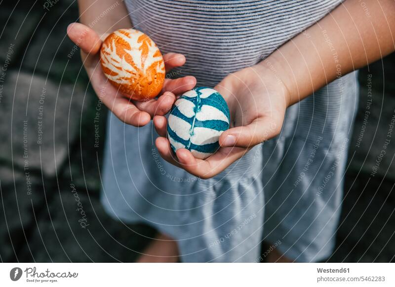Hands of baby girl holding organically colored Easter eggs outdoors location shots outdoor shot outdoor shots day daylight shot daylight shots day shots daytime