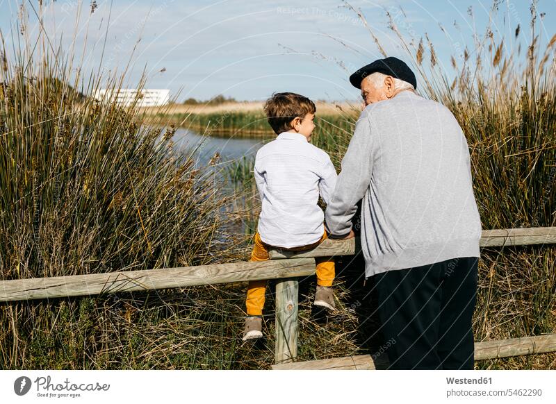 Back view of little boy and his grandfather looking at each other Spain high spirits good mood assistance Looking After support care rural scene Non Urban Scene