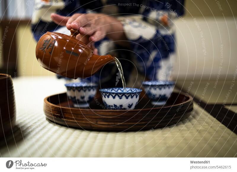 Japan, Hands of woman pouring tea into cups during tea ceremony indoors indoor shot indoor shots interior interior view Interiors Selective focus