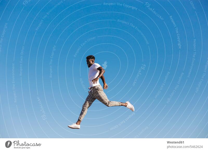 Young man jumping against clear blue sky during sunny day color image colour image Spain leisure activity leisure activities free time leisure time