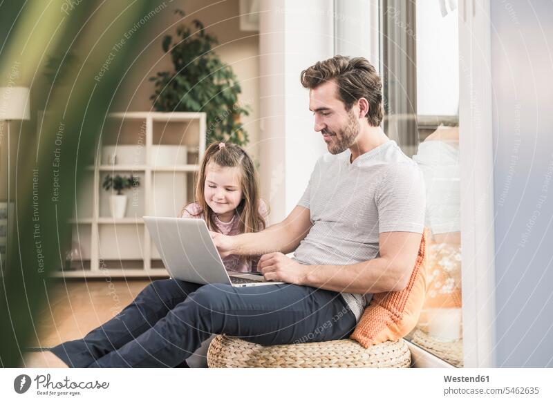 Young man and little girl surfing the net together Surfing the Net living room living rooms livingroom accessibility accessible online watching looking