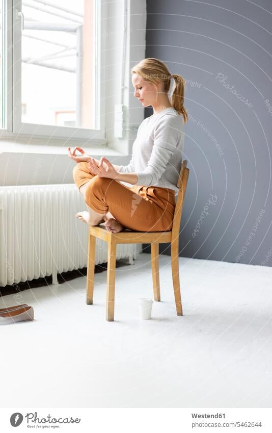 Young woman sitting on chair in office practicing yoga Occupation Work job jobs profession professional occupation business life business world business person