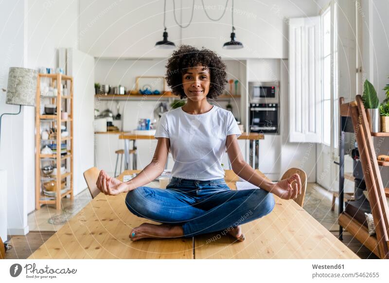 Portrait of smiling woman in yoga pose on table at home females women smile sitting Seated portrait portraits Table Tables Adults grown-ups grownups adult