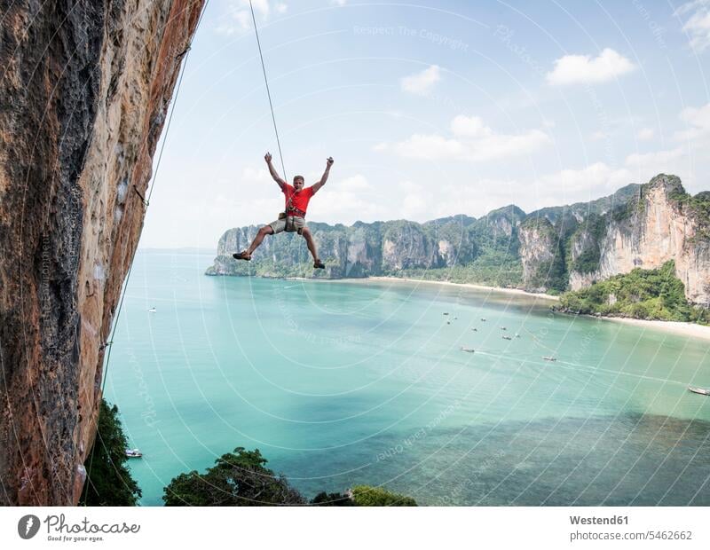Thailand, Krabi, Thaiwand wall, climber abseiling from rock wall above the sea rock face escarpment man males rocks ocean Rappelling rappeling climbing Adults