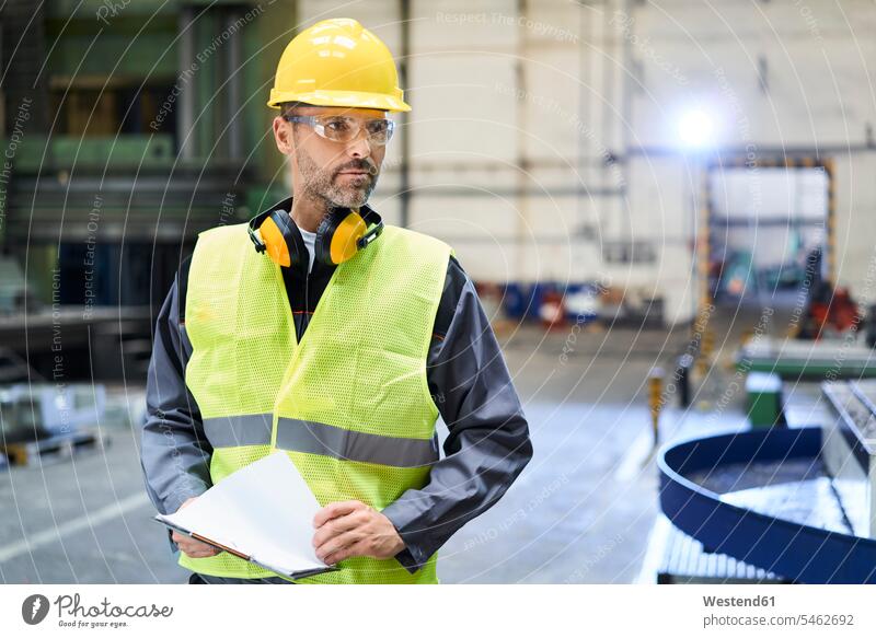 Man wearing protective workwear looking around in factory Protective Workwear Protective Work Wear man men males looking round look round look around industry