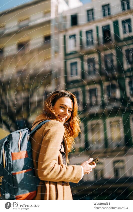 Portrait of happy young woman with backpack in the city, Lisbon, Portugal human human being human beings humans person persons celibate celibates singles
