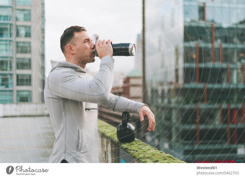 Man having a break from working out with a kettlebell in the city, Canada human human being human beings humans person persons short hairs short hairstyle