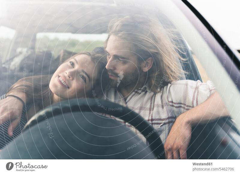 Affectionate young couple in a car twosomes partnership couples automobile Auto cars motorcars Automobiles people persons human being humans human beings