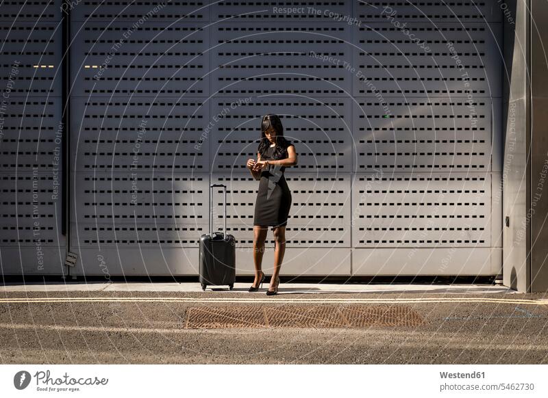 Businesswoman with trolley checking the time human human being human beings humans person persons African black black ethnicity coloured African American