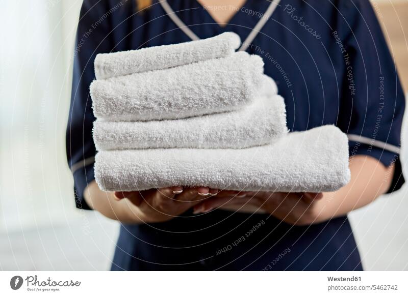 Close-up of chambermaid holding towels in hotel bedroom color image colour image indoors indoor shot indoor shots interior interior view Interiors Millennials