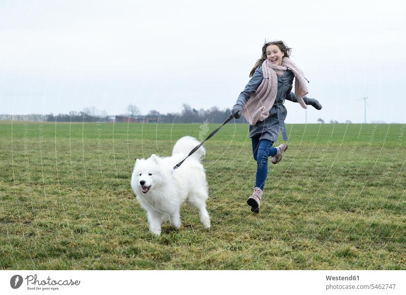 Laughing girl running on a meadow with her dog laughing Laughter females girls meadows dogs Canine positive Emotion Feeling Feelings Sentiments Emotions