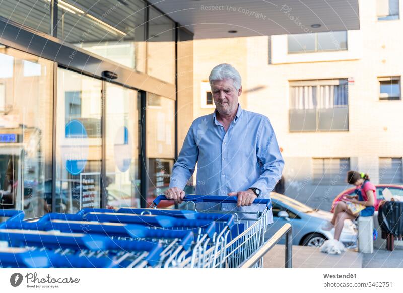 Senior man taking shopping cart at the supermarket human human being human beings humans person persons caucasian appearance caucasian ethnicity european 1