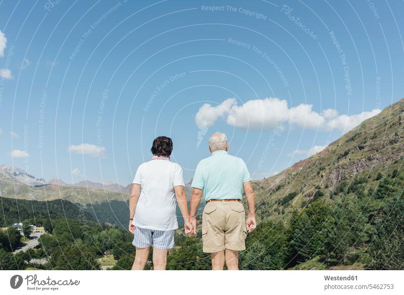 Back view of senior couple looking at view hand in hand, Jaca, Spain touristic tourists relax relaxing enjoy enjoyment indulgence indulging savoring happy