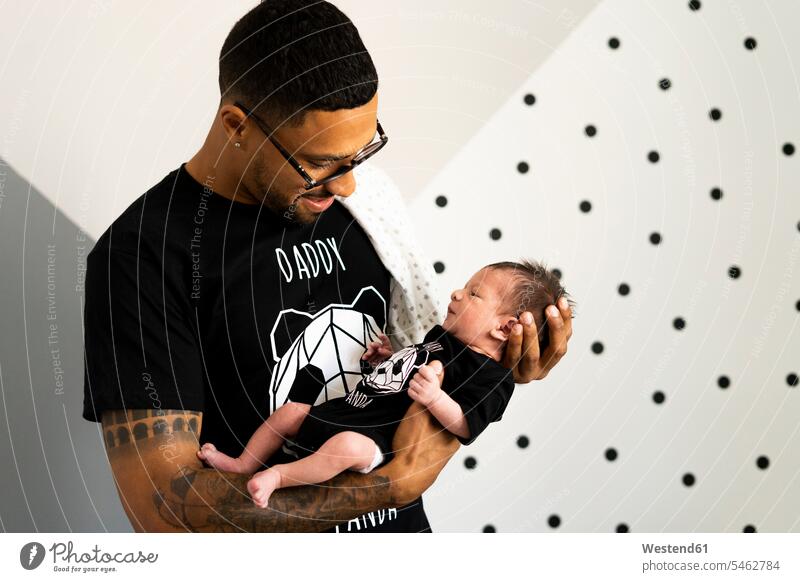Father holding his newborn baby multicultural fatherhood paternity Responsibility responsible tattooed t-shirt tee-shirt T- Shirt t-shirts dot dots dotted Spain