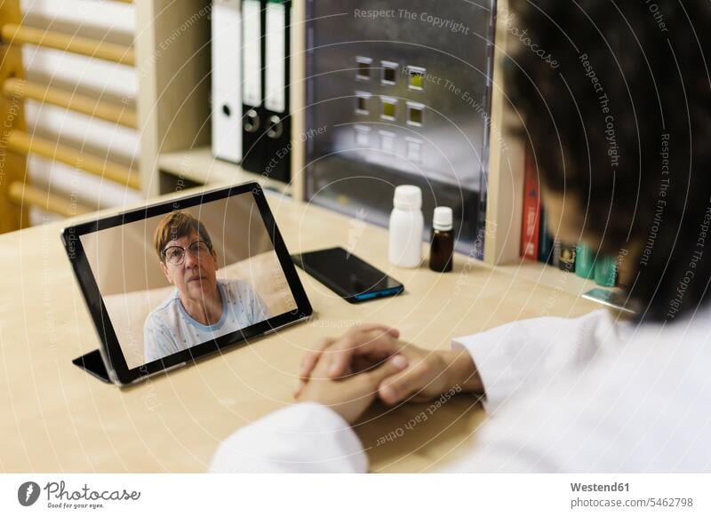 Senior woman on digital tablet screen during video call with doctor color image colour image Spain indoors indoor shot indoor shots interior interior view