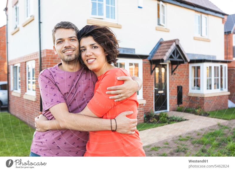 Portrait of happy couple hugging in front of their new home human human being human beings humans person persons caucasian appearance caucasian ethnicity