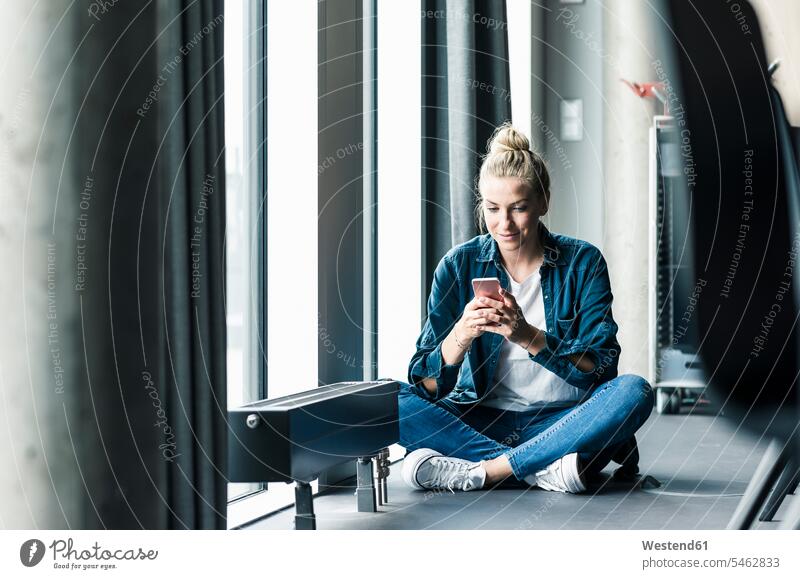 Businesswoman sitting on the floor in office using cell phone human human being human beings humans person persons caucasian appearance caucasian ethnicity